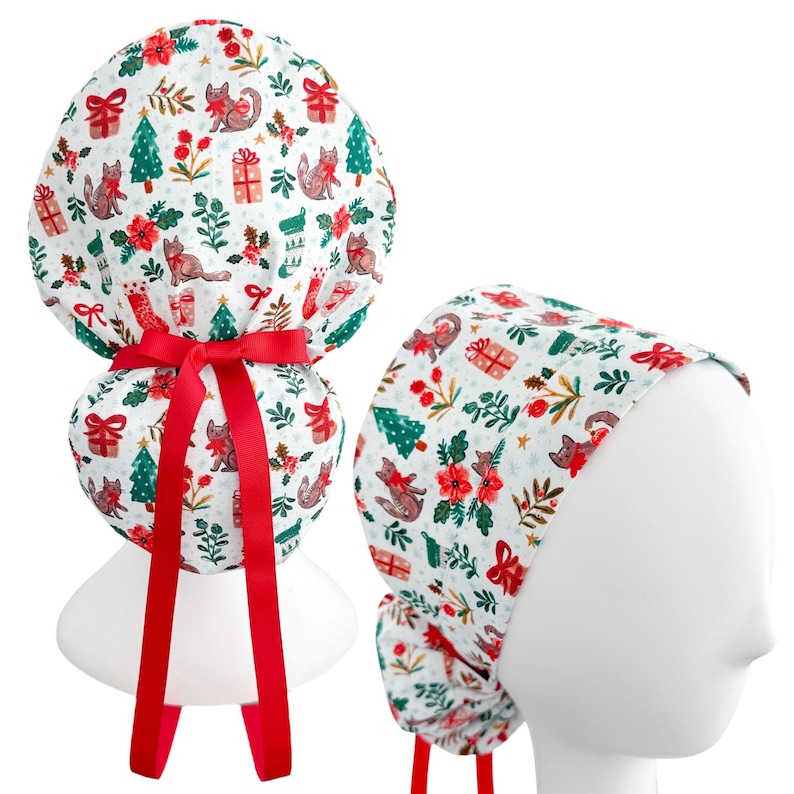 May include: A white scrub cap with a festive Christmas pattern featuring foxes, presents, Christmas trees, and red flowers. The cap has a red bow and ties. The second cap is on a mannequin head.