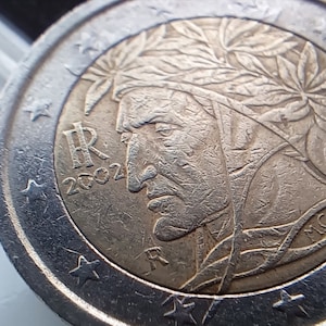 Op de afbeelding: Een zilveren 1 euro-munt uit Italië met een portret van een man met een lauwerkrans op zijn hoofd. De munt heeft het jaar 2002 en de letters "R" en "IR" erop.