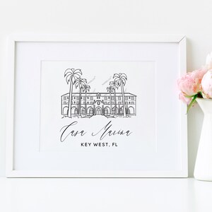 May include: A black and white line drawing of a building with palm trees in front of it. The text "Casa Marina" and "Key West, FL" is below the drawing.