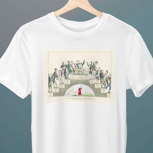 May include: White t-shirt featuring a vintage illustration of a group of people in period clothing. The artwork includes figures on a tiered structure and a person in a red coat. The text "THE ROUNDARDS" is visible.