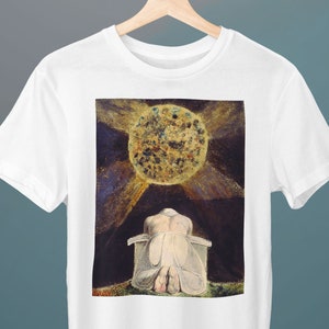 May include: White t-shirt with a print of a painting by William Blake. The painting depicts a figure kneeling beneath a large, golden sun.