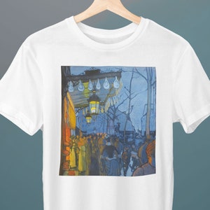 Puede incluir: Camiseta blanca con un estampado de una pintura que representa una escena callejera nocturna. La pintura muestra a un grupo de personas caminando bajo una farola con un cielo azul y árboles en el fondo.