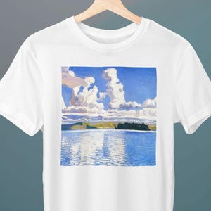 May include: White t-shirt with a blue and white painting of a lake and clouds. The painting is in a square shape and is centered on the shirt.