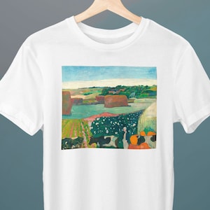 Peut inclure: Un t-shirt blanc avec une peinture colorée d'un paysage avec des vaches, des meules de foin et une rivière. La peinture est dans un style qui rappelle le post-impressionnisme.