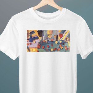 May include: A white t-shirt with a colorful painting of a still life featuring fruit, a vase, and figures. The painting is in a cubist style with geometric shapes and bright colors.