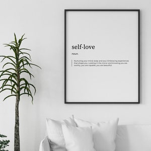 May include: A black framed print with the word "self-love" in bold, followed by the definition: "Nurturing your mind, body and soul. Embracing experiences that shape you. Looking in the mirror and knowing you are worthy, you are capable, you are beautiful."