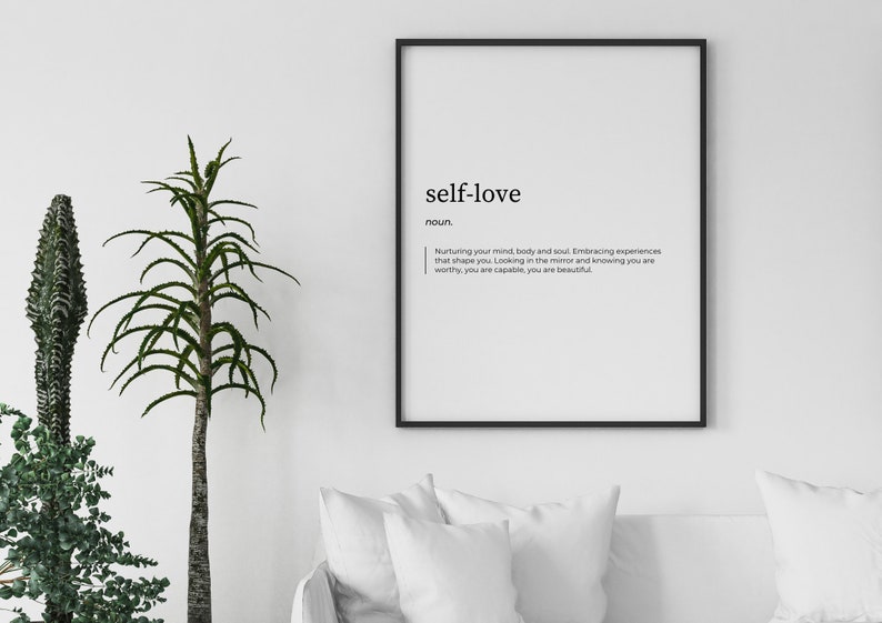 May include: A black framed print with the word "self-love" in bold, followed by the definition: "Nurturing your mind, body and soul. Embracing experiences that shape you. Looking in the mirror and knowing you are worthy, you are capable, you are beautiful."