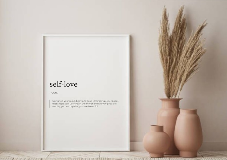 May include: A white framed print with the word "self-love" in black text, defined as "Nurturing your mind, body and soul. Embracing experiences that shape you. Looking in the mirror and knowing you are worthy, you are capable, you are beautiful."