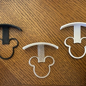 May include: Three 3D printed Mickey Mouse head shaped hooks in black, white, and translucent white.