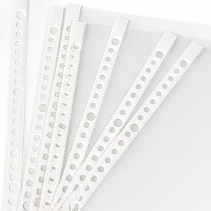 May include: A collection of clear plastic sheet protectors arranged in a fan pattern. Each protector features a reinforced white vertical strip along the left edge, containing a series of evenly spaced circular holes for insertion into a binder.
