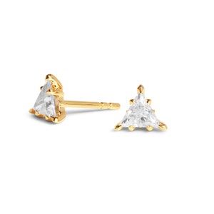 May include: A pair of gold triangle stud earrings with clear gemstones.