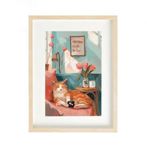 Peut inclure: Une impression d'art encadrée représente un chat tigré orange détendu sur un canapé rose. Une petite table contient un vase de tulipes. L'œuvre d'art comprend le texte "Offline feels better" dans un petit cadre, créant une scène intérieure chaleureuse.