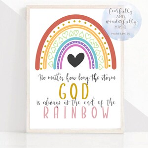 May include: A framed print featuring a colorful rainbow design with a black heart in the center. The text reads "No matter how long the storm, GOD is always at the end of the RAINBOW." A small circular graphic says "fearfully and wonderfully MADE Psalm 139:14."