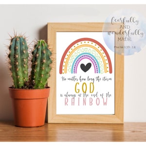 May include: A framed print with a colorful rainbow design and the text "No matter how long the storm GOD is always at the end of the RAINBOW." A small cactus in a terracotta pot sits to the left of the frame.