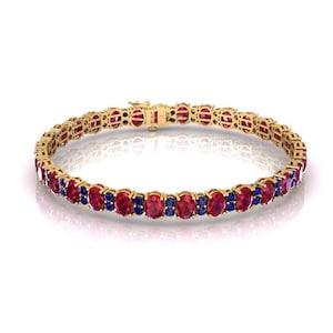 May include: A gold tennis bracelet with alternating red and blue gemstones. The bracelet is made of 14k gold and features a classic tennis chain design.