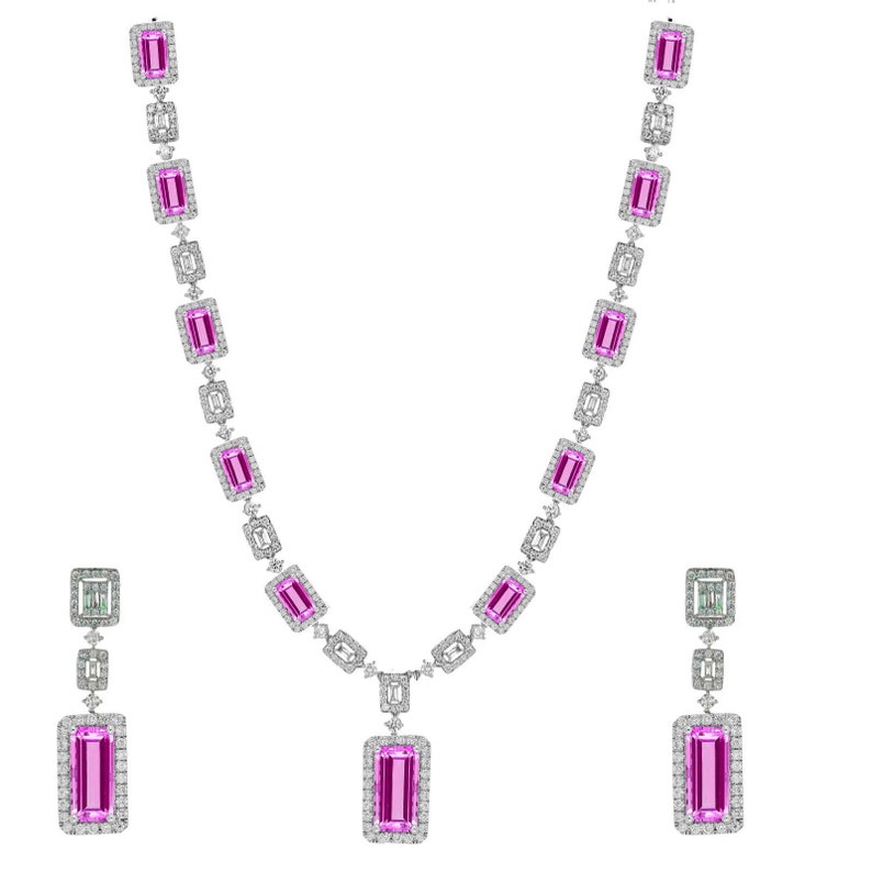 May include: A pink sapphire and diamond necklace and earrings set. The necklace features a pendant with a large rectangular pink sapphire surrounded by smaller diamonds. The earrings are drop earrings with a smaller rectangular pink sapphire surrounded by diamonds.