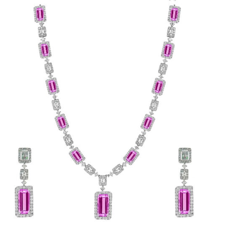 May include: A pink and white diamond necklace and earrings set. The necklace features a pendant with a large pink rectangular stone surrounded by smaller diamonds. The earrings are drop earrings with a pink rectangular stone and smaller diamonds.