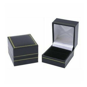 May include: Two black ring boxes with gold trim. One box is closed and the other is open, revealing a black velvet interior.
