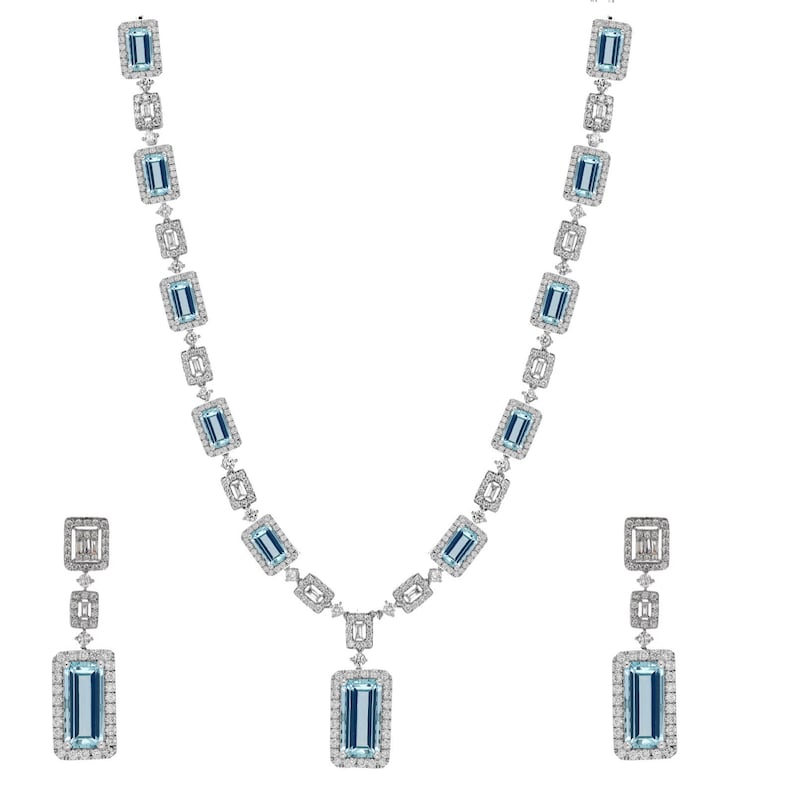 May include: A set of aquamarine and diamond jewelry featuring a necklace and earrings. The necklace has a pendant with a large aquamarine stone surrounded by smaller diamonds. The earrings are drop earrings with a similar design.