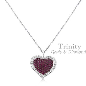 May include: A silver chain necklace with a heart-shaped pendant. The pendant is covered in small red gemstones and outlined with smaller white gemstones. The pendant is surrounded by a silver frame. The necklace is from Trinity Golds & Diamonds.