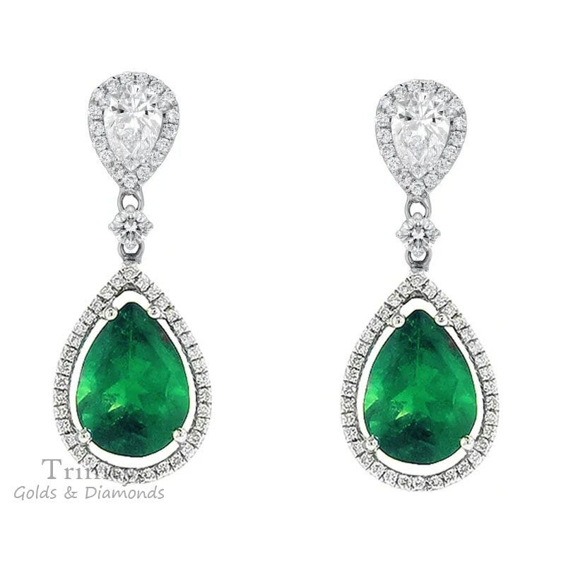 May include: A pair of pear-shaped emerald and diamond drop earrings. The emeralds are a vibrant green and are surrounded by a halo of smaller diamonds. The earrings are suspended from a delicate chain with a small diamond accent.