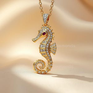 以下が含まれることがあります： 金色のタツノオトシゴペンダントネックレス。タツノオトシゴは小さな透明な宝石で装飾され、赤い宝石の目があります。ネックレスは繊細なゴールドチェーンに掛かっており、エレガントなジュエリーです。