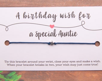 May include: A white card with the text "A birthday wish for a Special Auntie" and a blue string bracelet with a silver star charm. The card also includes the text "Tie this bracelet around your wrist, close your eyes and make a wish. When your bracelet breaks in two, your wish may just come true!"