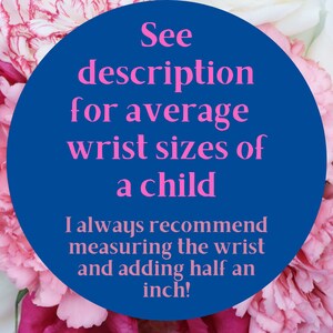 May include: A blue circle with white text that reads "See description for average wrist sizes of a child. I always recommend measuring the wrist and adding half an inch!" The circle is surrounded by pink and white flowers.