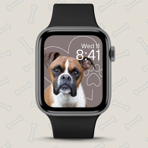 May include: A black Apple Watch with a brown and white boxer dog on the screen. The watch face shows the time as 8:41 and the day as Wed 11. The background of the watch face is a light brown color with a white heart and paw print.