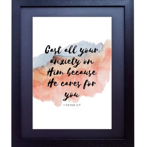 May include: A framed print with a watercolor background in shades of pink and blue. The print features a quote from the Bible, 1 Peter 5:7, which reads "Cast all your anxiety on Him because He cares for you."