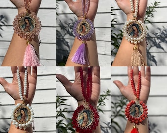 Puede incluir: Seis diferentes amuletos para el coche con una cadena de cuentas y un amuleto redondo con una imagen de la Virgen María. Los amuletos están disponibles en rosa, morado, blanco, rojo, beige y dorado.