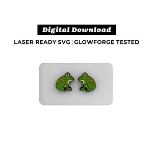May include: A pair of green frog earrings on a white background. The earrings are laser cut and ready to be used for crafting projects.