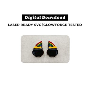 Può includere: Un paio di orecchini neri a forma di pentola d'oro con cime arcobaleno. Gli orecchini sono in legno e sono tagliati al laser.