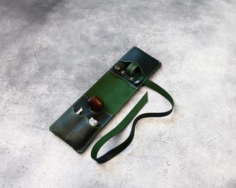 May include: A green leather carrying case with a strap and multiple pockets. The case is open and shows a small pipe, a lighter, and a small tool.