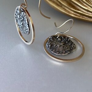 Earrings: fine silver floral imprint encircled with 14K gold-filled square wire