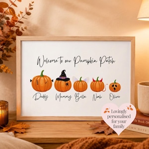 Puede incluir: Una impresión horizontal enmarcada con el texto Welcome to our Pumpkin Patch. Debajo hay cinco calabazas naranjas con detalles como un sombrero de bruja, alas de hada y cuernos de diablo, etiquetadas con los nombres Daddy, Mummy, Bella, Noah y Oliver.