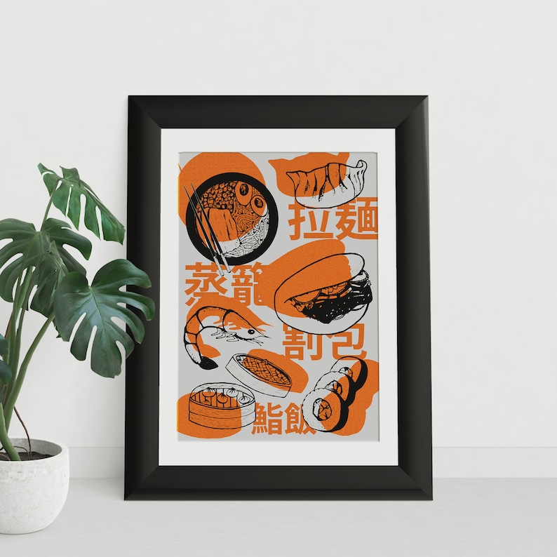 May include: A framed print with a white background and orange accents. The print features a variety of Asian food illustrations, including dumplings, noodles, prawns, and sushi. The text on the print reads "饺子面", "家常", "寿司", and "割包".