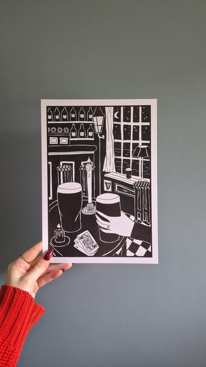 May include: Black and white illustration of a pub scene with two pints of beer, a lit candle, and playing cards on a checkered table. The scene is set at night with a window view of a moon and stars.