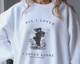 May include: White sweatshirt with a black and white illustration of a woman walking in a field. The text "All I Loved I Loved Alone Edgar Allen Poe" is printed on the sweatshirt.