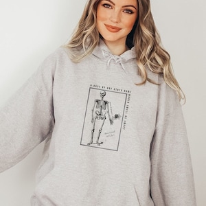 May include: Gray hooded sweatshirt with a black and white illustration of a skeleton holding a rose. The text "A rose by any other name... would smell as sweet" is printed on the sweatshirt.