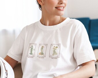 Puede incluir: Camiseta blanca con un gráfico de tres cartas de tarot. Las cartas están etiquetadas como "The Lunatic", "The Lover" y "The Poet".