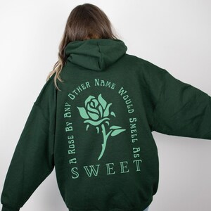 May include: A dark green hoodie with a light green rose graphic and the text "A rose by any other name would smell as sweet".