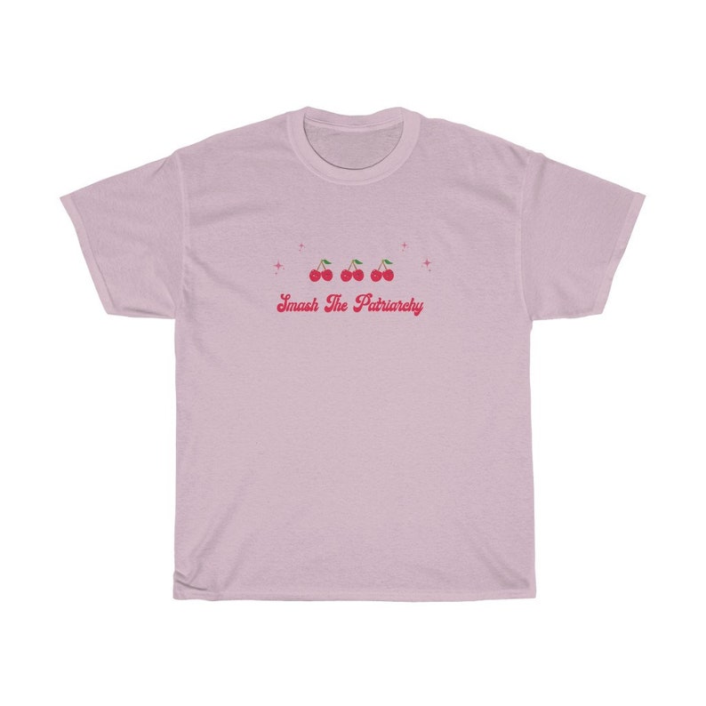 May include: A light pink t-shirt with a graphic of four red cherries and the text "Smash The Patriarchy" in pink.