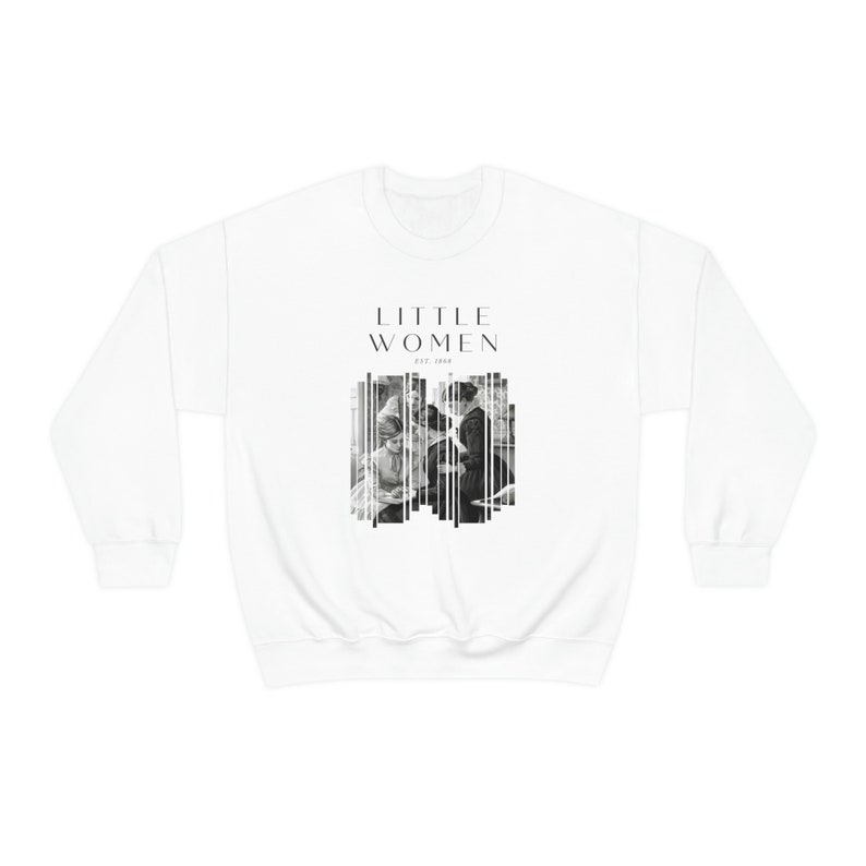 K&ouml;nnte beinhalten: Wei&szlig;er Pullover mit einem schwarzen grafischen Druck des Textes "LITTLE WOMEN" und einem Schwarzwei&szlig;bild von vier Frauen. Der Text "EST. 1868" ist unter dem Text "LITTLE WOMEN" gedruckt.