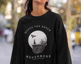 May include: Black sweatshirt with a white graphic print of a raven flying over a moonlit scene. The text "Quoth the Raven" and "Nevermore" are printed below the image. The text "Edgar Allen Poe" is printed below the text "Nevermore".