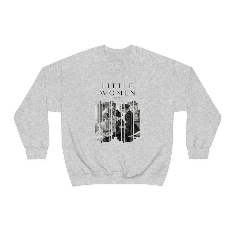 K&ouml;nnte beinhalten: Ein grauer Pullover mit einem schwarz-wei&szlig;en Grafikdruck einer Gruppe von Frauen. Der Text "LITTLE WOMEN" ist &uuml;ber dem Grafikdruck gedruckt, mit dem Text "EST. 1868" unter dem Grafikdruck.