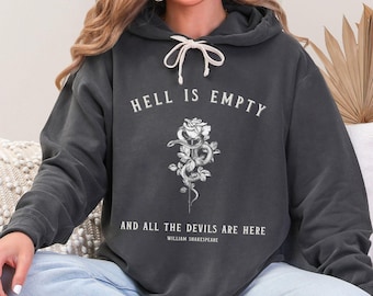 May include: A dark gray hoodie with a white graphic print of a rose with a snake wrapped around it. The text "Hell is empty and all the devils are here" is printed below the rose, with the attribution "William Shakespeare" underneath.