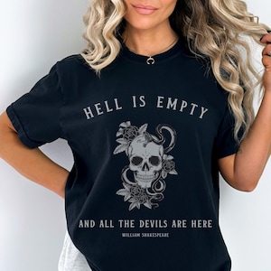 Puede incluir: Camiseta negra con un gráfico de calavera y serpiente y el texto "El infierno está vacío y todos los demonios están aquí" de William Shakespeare.