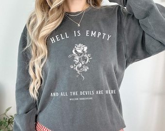 May include: A gray sweatshirt with the text "Hell is empty and all the devils are here" and a black and white illustration of a rose with a snake wrapped around it. The text "William Shakespeare" is below the illustration.