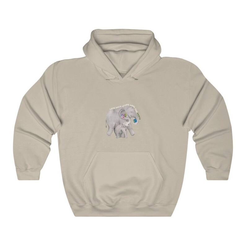Op de afbeelding: Een licht beige hoodie met een afbeelding van een moeder- en babyolifant. De moederolifant houdt een wereldbol in haar slurf. De tekst "Love Each Other Love The Earth" is rond de olifanten gedrukt.